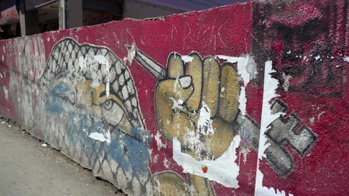 Graffiti in Ramallah showing masked Palestinian holding a key and pencil